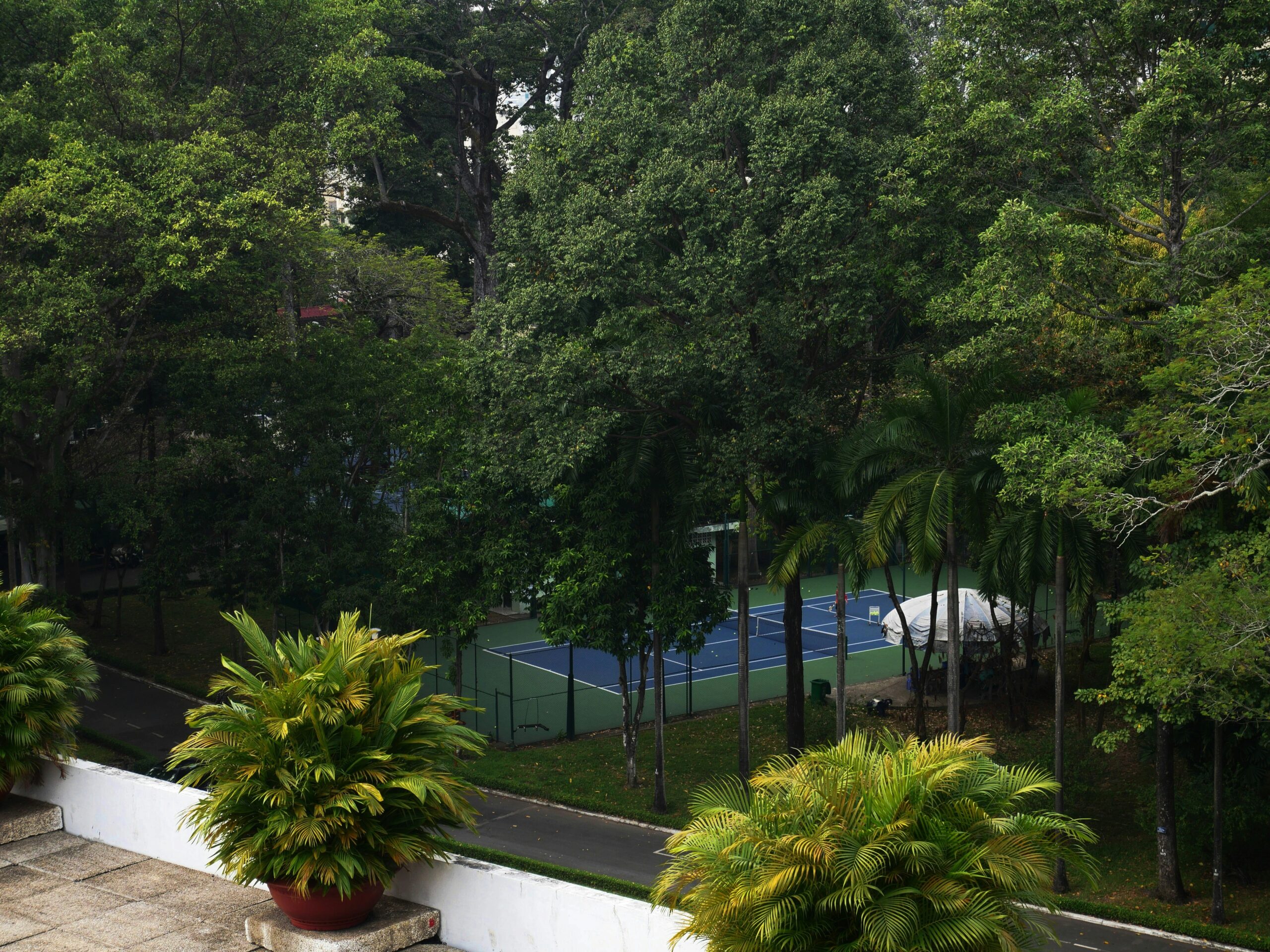 a tennis court surrounded by trees and bushes